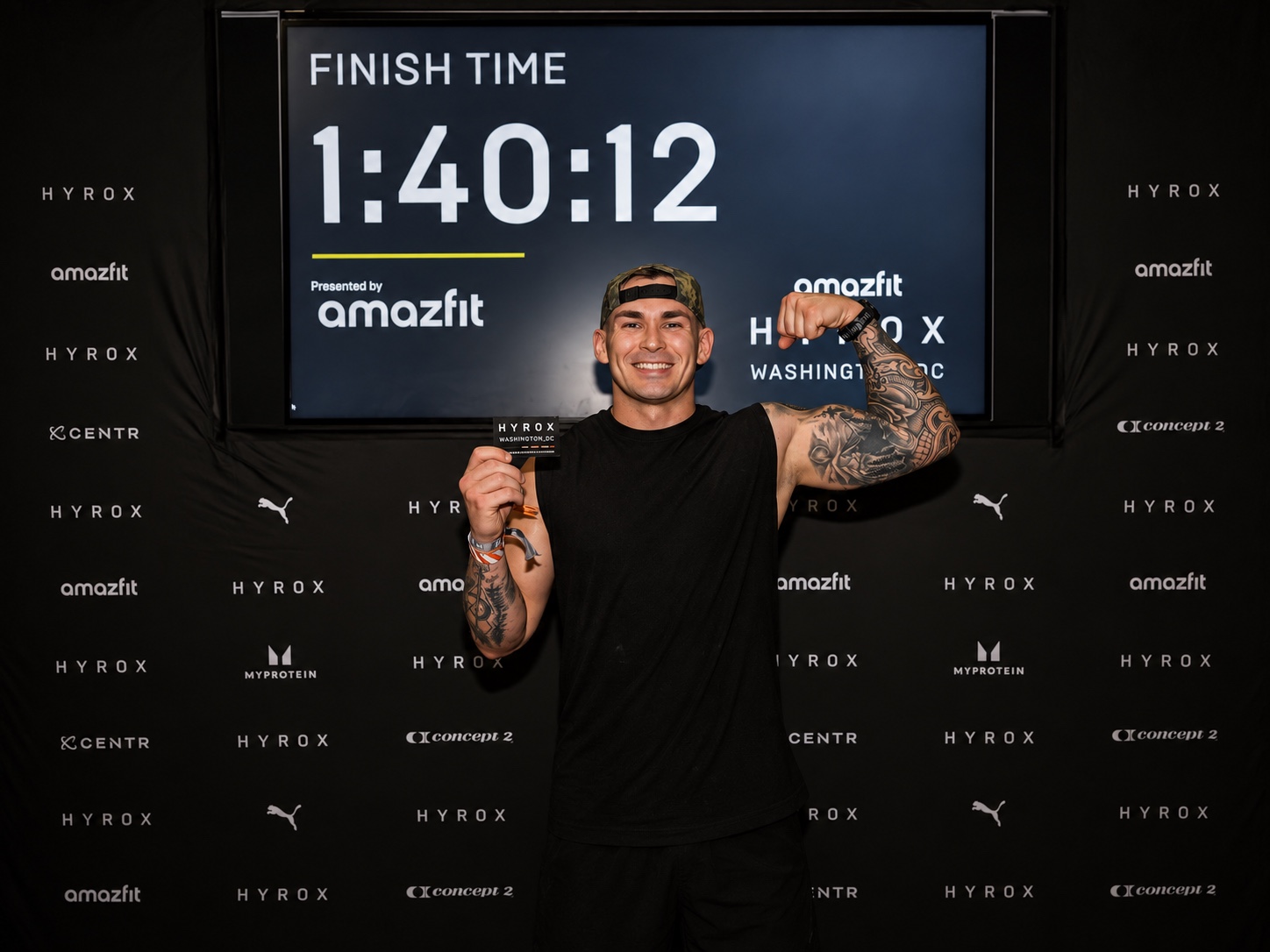 Jake smiling and flexing at the HYROX finish line